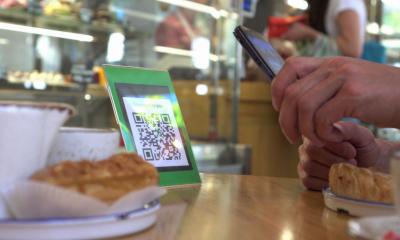 A male customer pays for his order using a QR code
